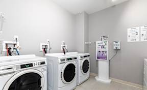 A laundromat with washers and dryers and a sign on the wall.