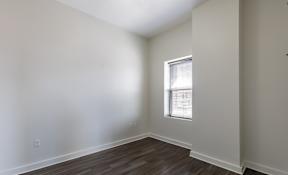 A room with a window and wooden flooring.