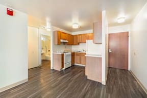 A kitchen with wooden floors and cabinets.