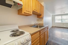 A kitchen with a white stove and wooden cabinets.