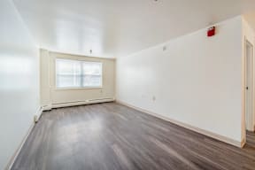 A room with a window and wooden flooring.