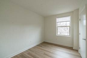 A room with a window and wooden flooring.