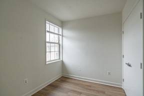 A room with a window and wooden flooring.