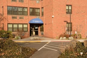 A brick building with a blue awning that says "Stamford Place" in front of it.