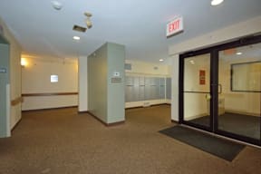 A hallway with a red exit sign above the door.