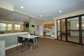 A kitchen with a table and chairs in the foreground.