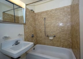 A bathroom with a white sink and a bathtub.