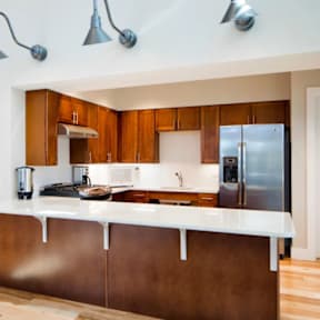A kitchen with brown cabinets and a white counter.