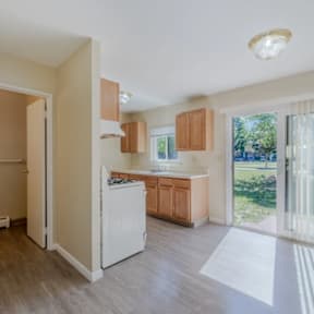 A kitchen with a white refrigerator and wooden cabinets.
