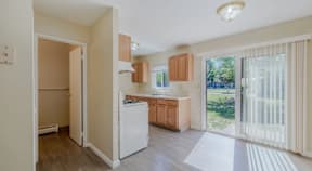 A kitchen with white appliances and wooden cabinets.
