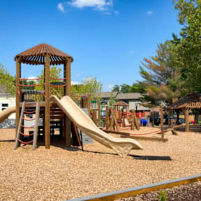 A playground with a wooden structure and a slide.