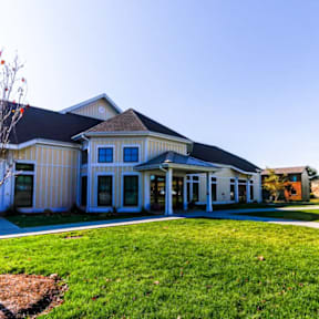 A white building with a black roof and a covered walkway.