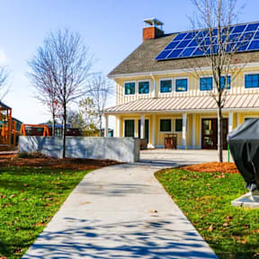 A house with solar panels on the roof and a statue in front.