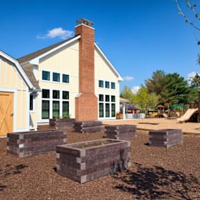 A house with a red brick chimney and a playground in front.