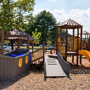 A playground with a wooden structure and a slide.