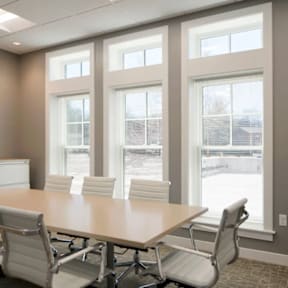 A conference room with a long table and chairs.