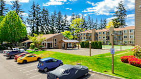A parking lot with cars and a building in the background.