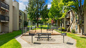 A picnic table is in the middle of a playground in a residential area.