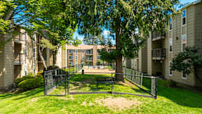 A sunny day at a residential complex with a playground in the foreground.