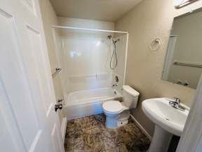 A small bathroom with a toilet, sink, and bathtub.