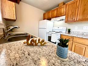 A kitchen with granite countertops and a white fridge.