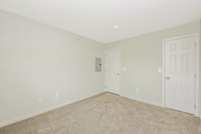 a bedroom with a carpeted floor and a white door  at Platt Gardens, West Babylon, NY