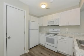 a kitchen with white cabinets and white appliances  at Platt Gardens, West Babylon, 11704