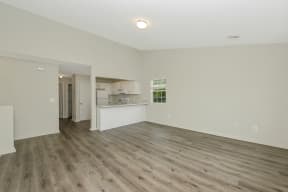 an empty living room with a kitchen in the background  at Platt Gardens, West Babylon, 11704