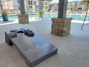 a stone bench with towels on it and a pool in the background at Reserve of Bossier City Apartment Homes, Bossier City, Louisiana, 71111