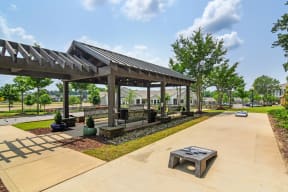a picnic shelter with a firepit at the whispering winds apartments in pearland, tx