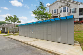 a detached garage with a blue roof and a gray house in the background