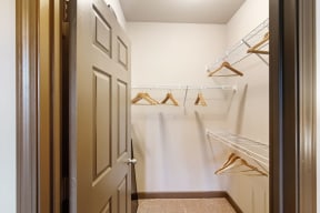 a walk in closet with white walls and a white door at Audubon Park Apartment Homes, Louisiana