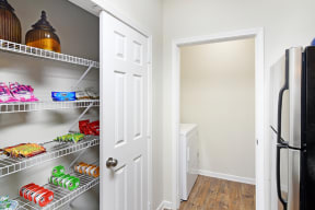a pantry with a refrigerator and a washer and dryer