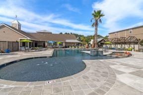 a resort style pool with lounge chairs and umbrellas  at Reserve at Gulf Hills Apartment Homes, Mississippi