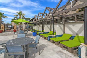 a patio with a table and chairs and green umbrellas  at Reserve at Gulf Hills Apartment Homes, Mississippi
