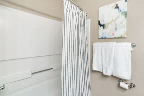 a bathroom with a striped shower curtain and white towels