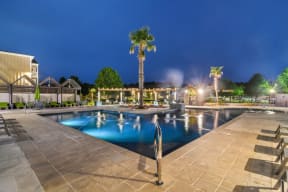 a resort style swimming pool with palm trees in the background  at Reserve at Gulf Hills Apartment Homes, Ocean Springs