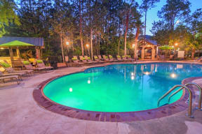 a resort style pool with lounge chairs and a gazebo