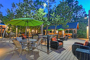 a large deck with tables and chairs and umbrellas