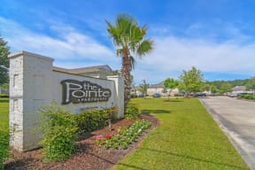 the pointe apartments sign and landscaping