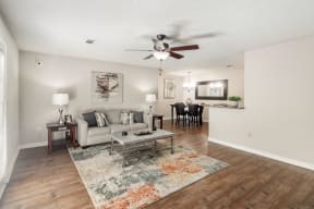 a living room with a ceiling fan and hardwood floors