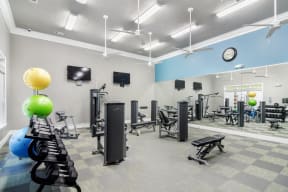 a fitness center with treadmills and weights at the monarch luxury apartments in des plaines
