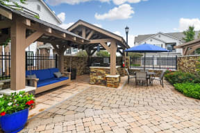 a patio with a couch and a table with a blue umbrella  at Kingston Crossing Apartment Homes, Bossier City, LA, 71111