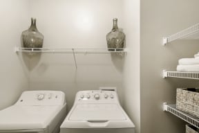 a laundry room with two washers and two shelves