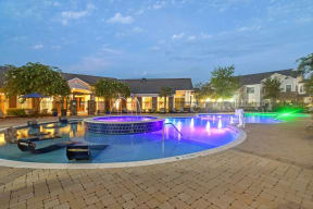a large pool with a blue and purple lighted water feature  at Kingston Crossing Apartment Homes, Bossier City