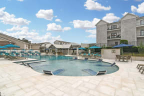 a resort style pool with lounge chairs and umbrellas at the villas at falling waters  at Parkwest Apartment Homes, Mississippi