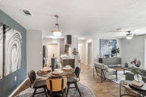 a dining room and living room with a table and chairs and a kitchen in the background  at Parkwest Apartment Homes, Hattiesburg, MS
