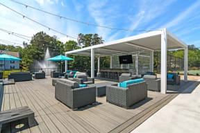 a patio with wicker couches and chairs and a flat screen tv