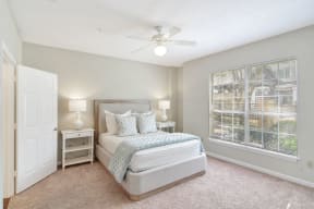 a bedroom with a bed next to a window