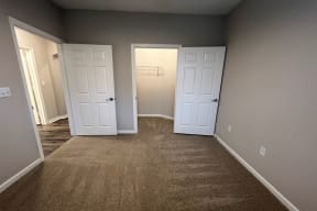 a empty room with two doors and a carpeted floor